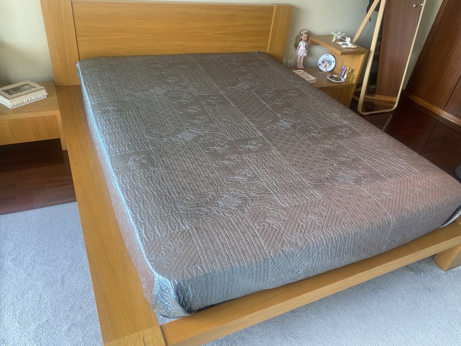 Quarto com cama de casal, colchao e mesinhas de cabeceira