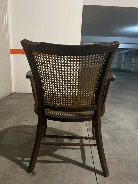 Cadeira de madeira rústica com braços e assento de palha