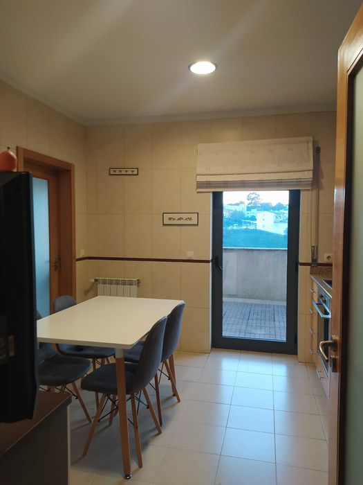 Mesa de cozinha com quatro cadeiras e um móvel igual