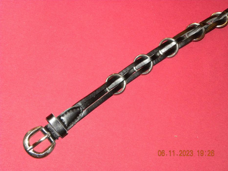 Pasek czarny z ozdobnymi kółkami.