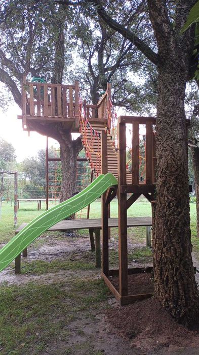 Parque infantil na árvore con tirolesa e ponte suspensa.