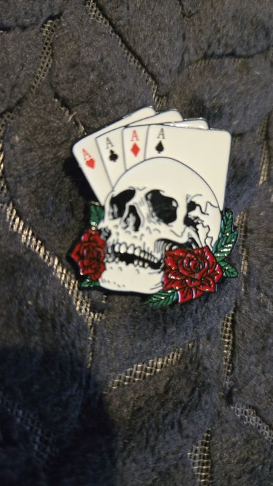 Przypinka karty i czaszka.