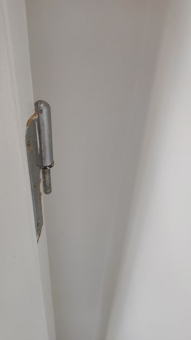 Porta de interior branca com puxador, fechadura e dobradiças