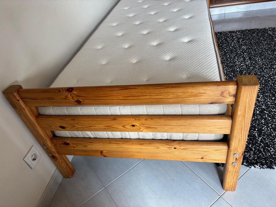 Cama em madeira maciça e colchão.