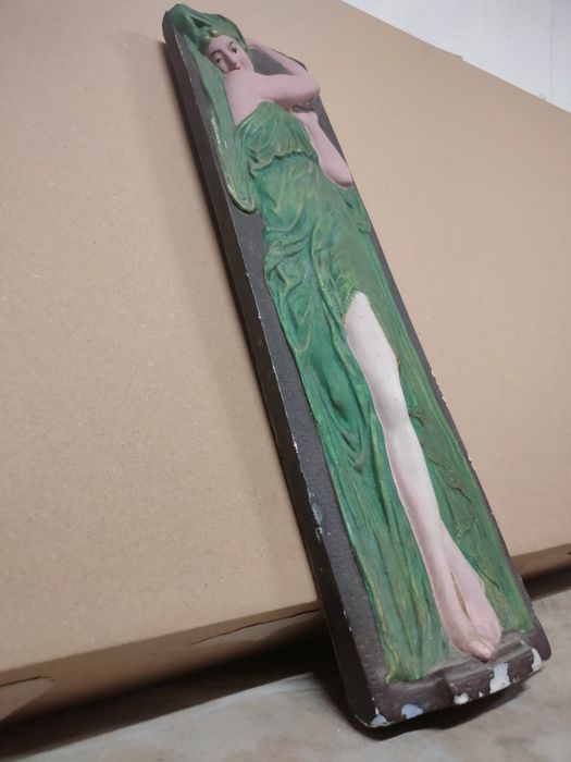 Placa em gesso de figura feminina em relevo.