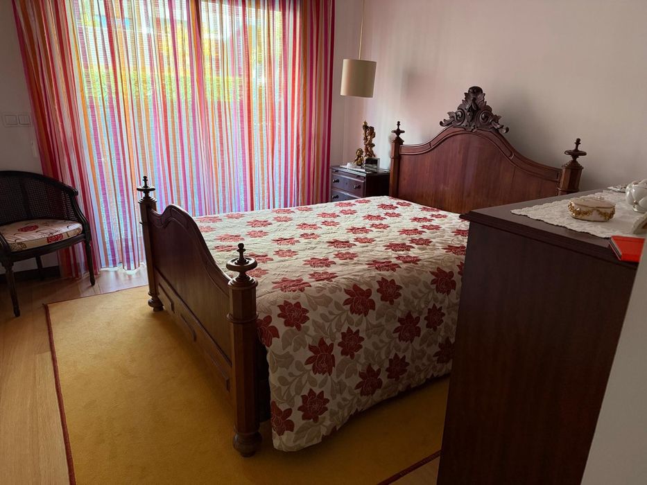 Cama antiga e mesinha de cabeceira