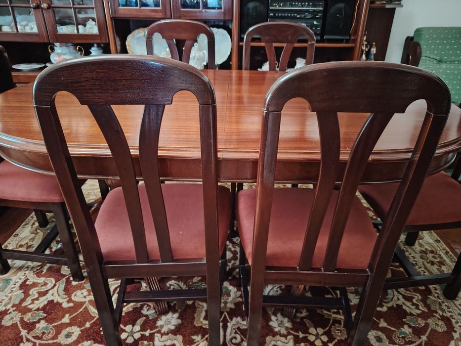 Mesa de sala de jantar com 6 cadeiras forradas a veludo rosa.