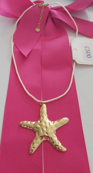 Colar dourado, em aço, com pingente em forma de estrela. Tem extensor