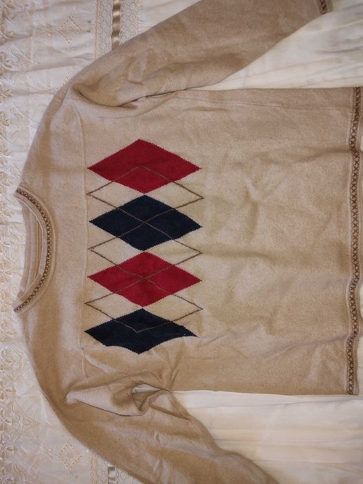 Camisola bege com padrão azul e vermelho