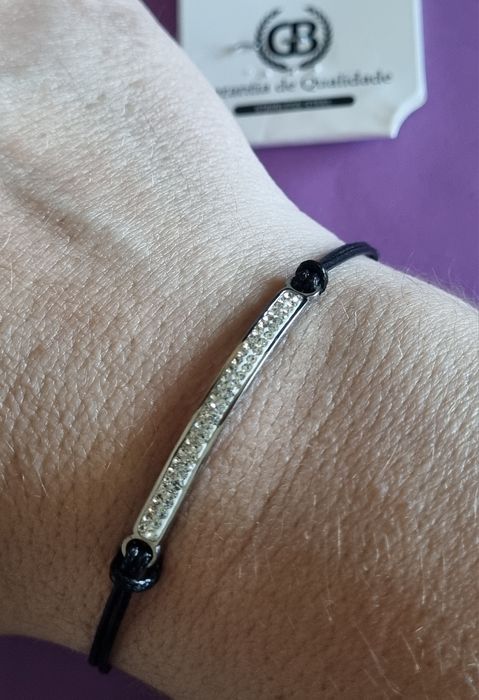 Pulseira preta e prateada, em aço. Chapinha com 2 fiadas de zirconias. Ajustável