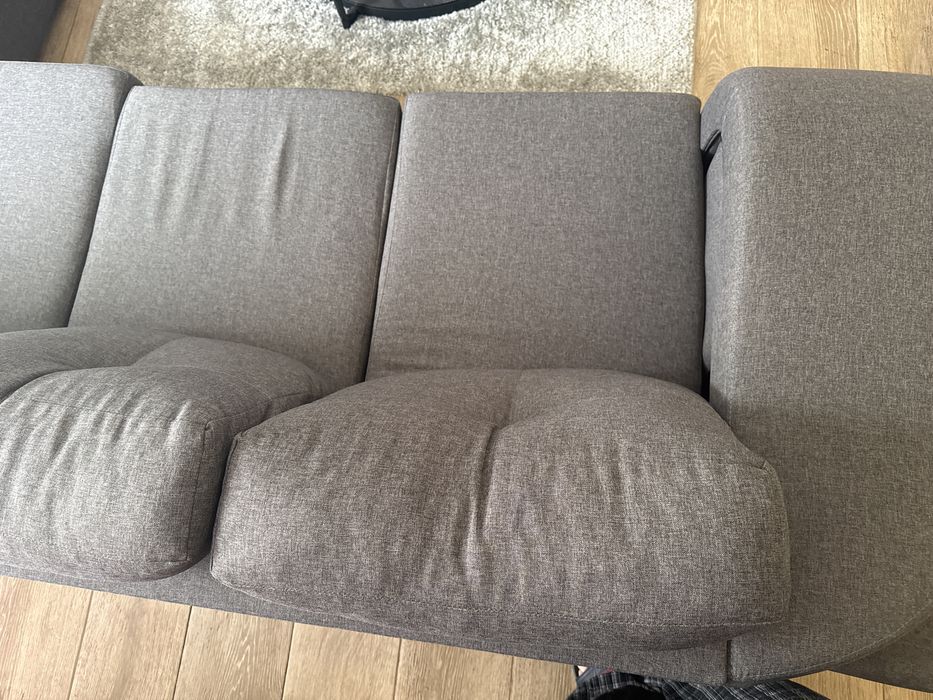 sofa cinza e conta com 4 puffs