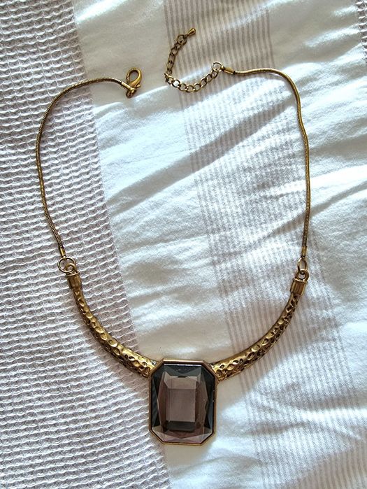 Colar dourado com uma pedra