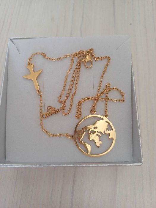 Łańcuszek celebrytka z mapą świata i samolotem.