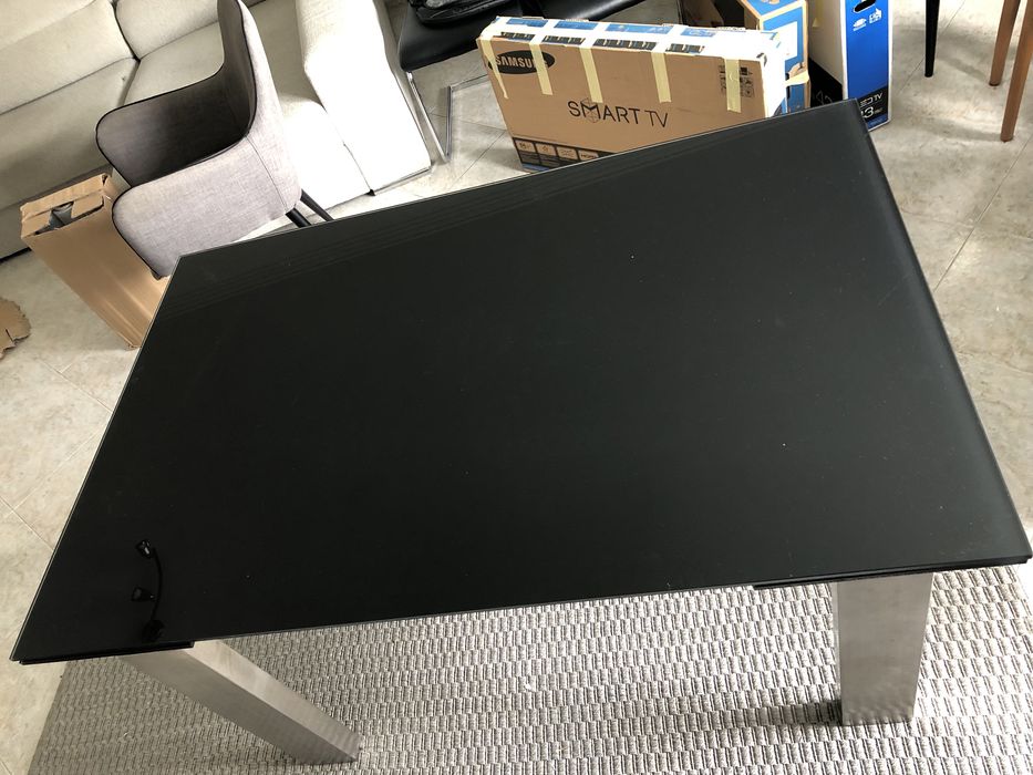 Mesa de vidro escuro, com pés em alumínio.