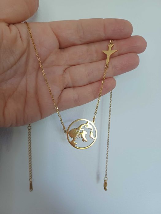 Łańcuszek celebrytka z mapą świata i samolotem.