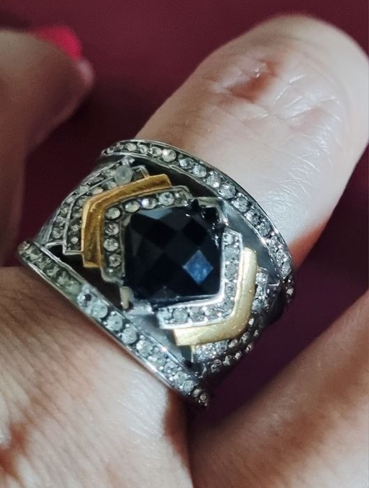Anel prateado, em aço, com zirconias e uma pedra preta lapidada. T19