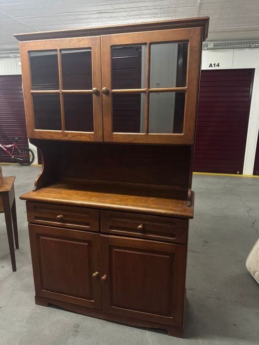 traditional cherry wood hutch with glass doors and storage below.