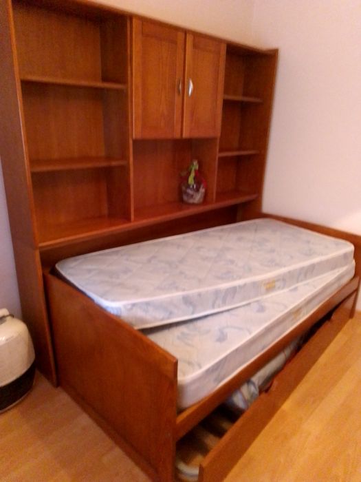Estúdio com duas camas individuais ,tem função de quarto  de salinha de estar .as cama podem se por de versatil encaixada na estante ao meio   de lado