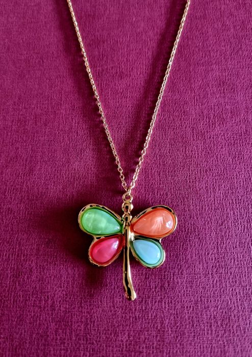 Colar dourado, em aço, com libelinha colorida. Tem extensor