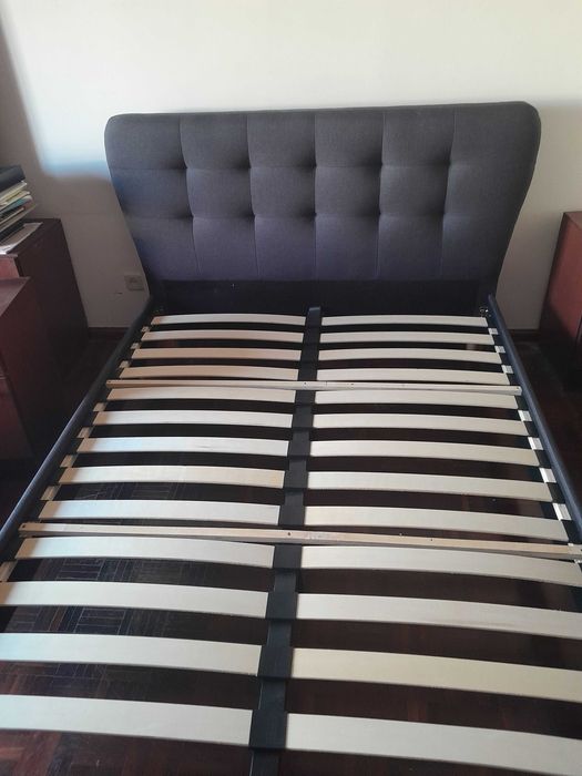Cama de casal estofada em tecido cinzento-escuro com cabeceira e estrado