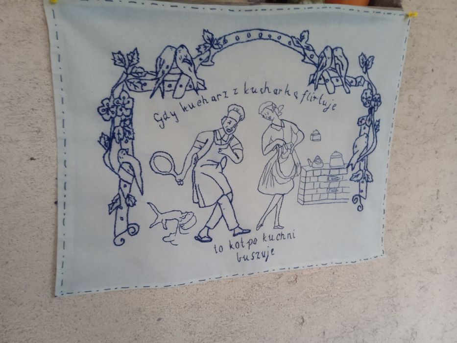Makatka ścienna haft ręczny Gdy kucharz z kucharką flirtuje to kot po kuchni buszuje.