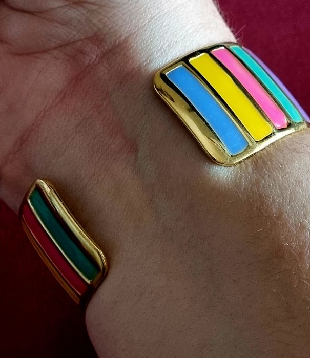 Pulseira dourada, em aço, com riscas coloridas. Fácil colocação.