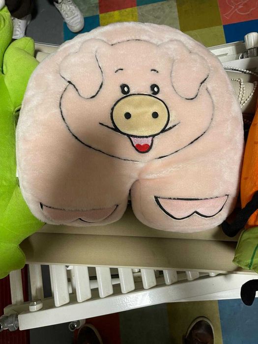 Diversos peluches e almofadas infantis