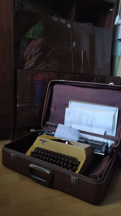 Łucznik PRL – żółta maszyna do pisania z walizką i dokumentami