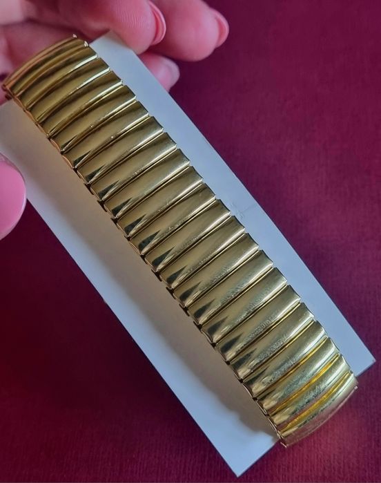 Relógio dourado, elástico, com mostrador em aço.