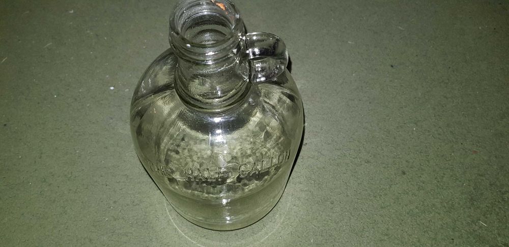 Garrafões de vidro com pega "ONE GALLON" e "ONE HALF GALLON"