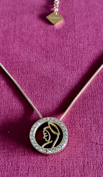 Colar dourado, em aço, com pingente da Nossa Senhora rodeada de zirconias.