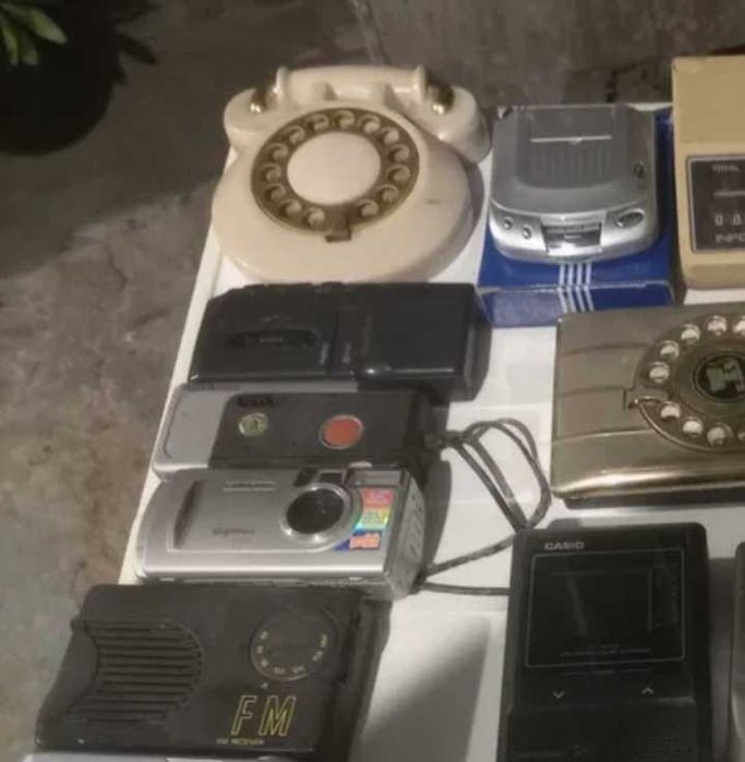 Rádios antigos entre outros eletrônicos para colecionadores