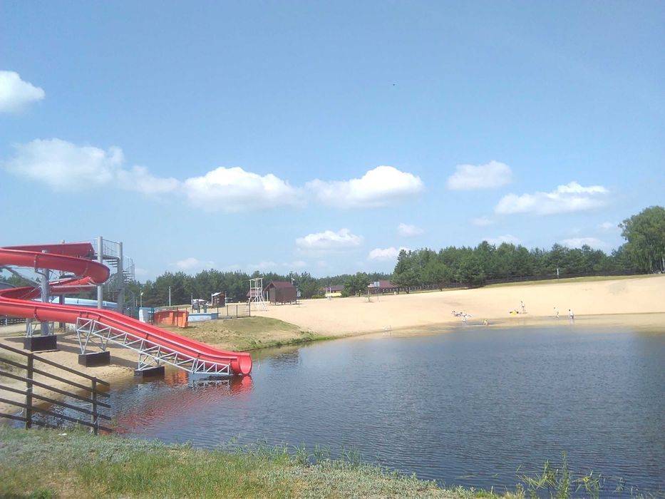 Domek nad zalewem na ogrodzonej działce.