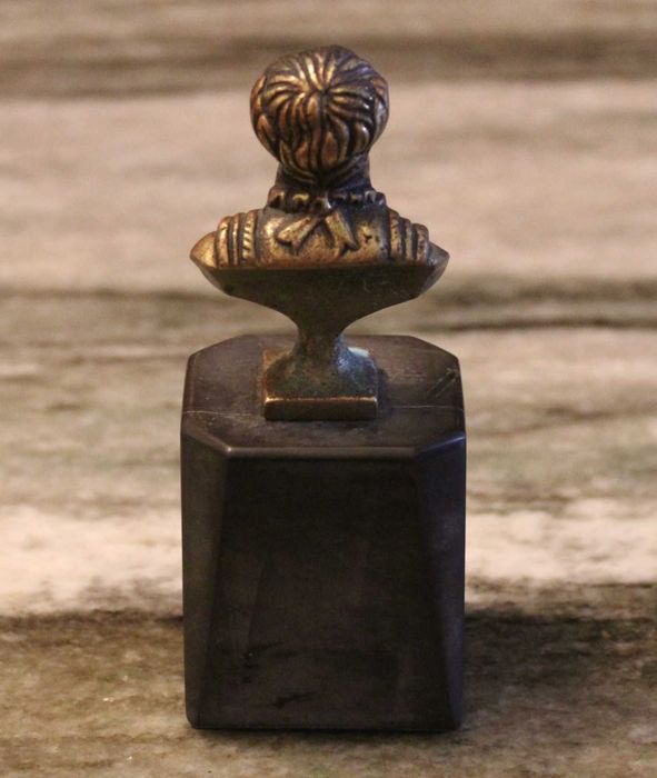 Busto de Luís Vaz de Camões com 12cm de altura, bronze sobre mármore.