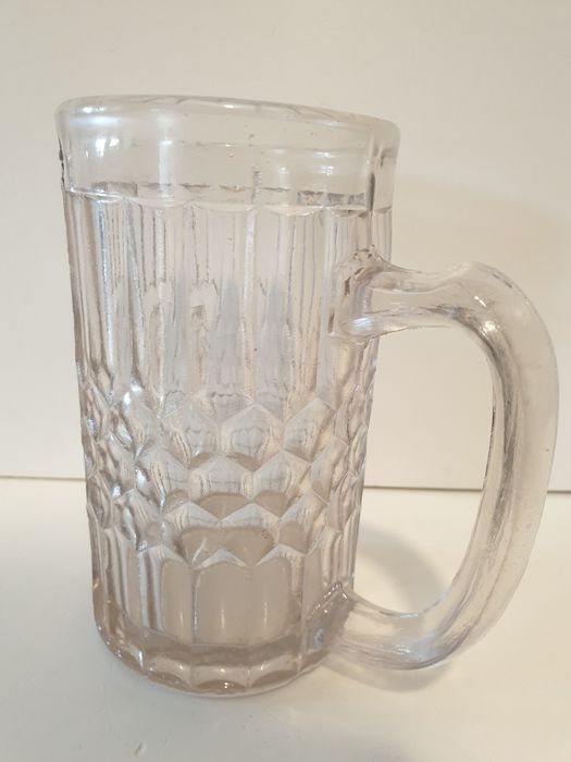 Antiga caneca de cerveja com cabeça de leão em vidro prensado