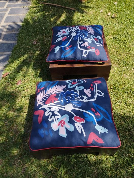 Dois bancos de jardim com almofadas.