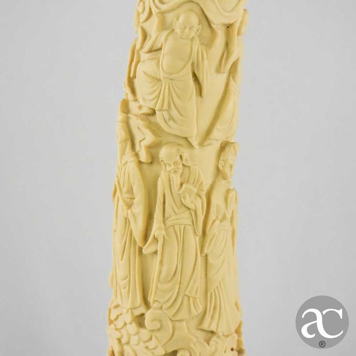 Escultura marfinite forma de dente de elefante com figuras orientais