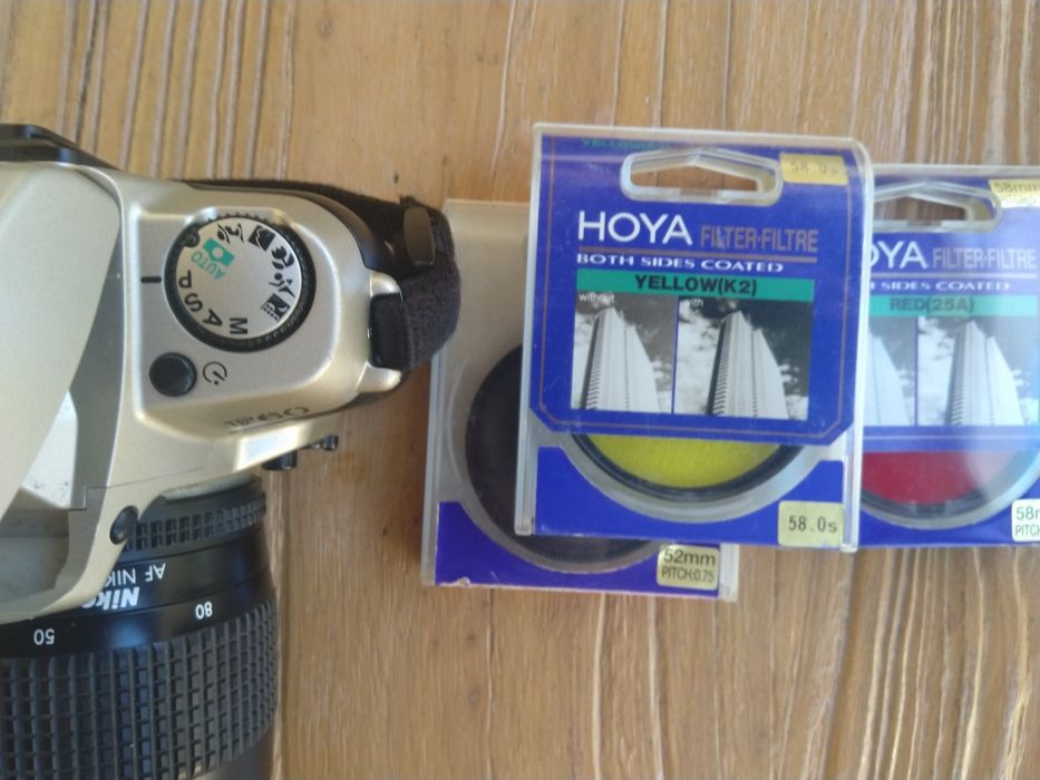 Nikon F60 com teleobjetiva, filtros, rolos