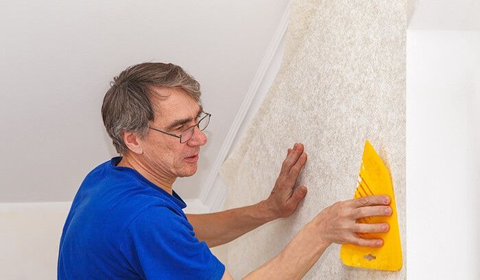 Aplicação de papel de parede e adesivo.