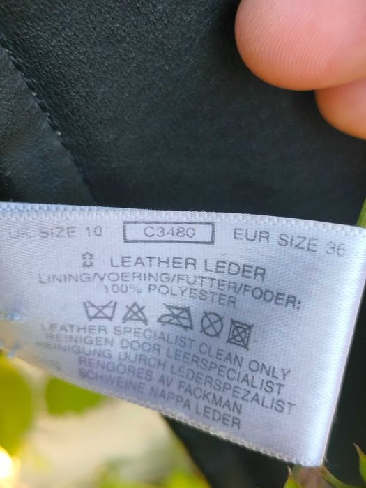 Куртка чорного кольору з натуральної шкіри з капюшоном, утеплена.