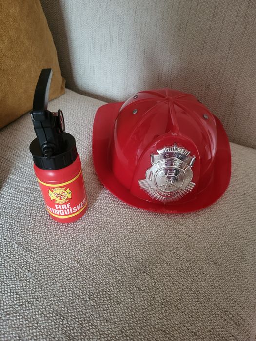 Capacete e extintor de bombeiros.