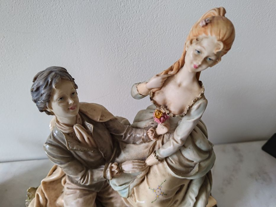 Estátua de dois amantes em base de madeira