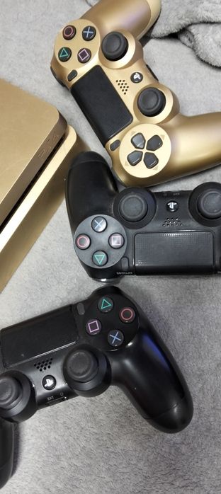 PS4 dourada com 3 comandos