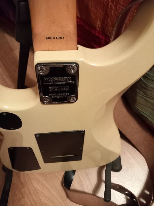 Guitarra eléctrica em caixa com suporte e amplificador