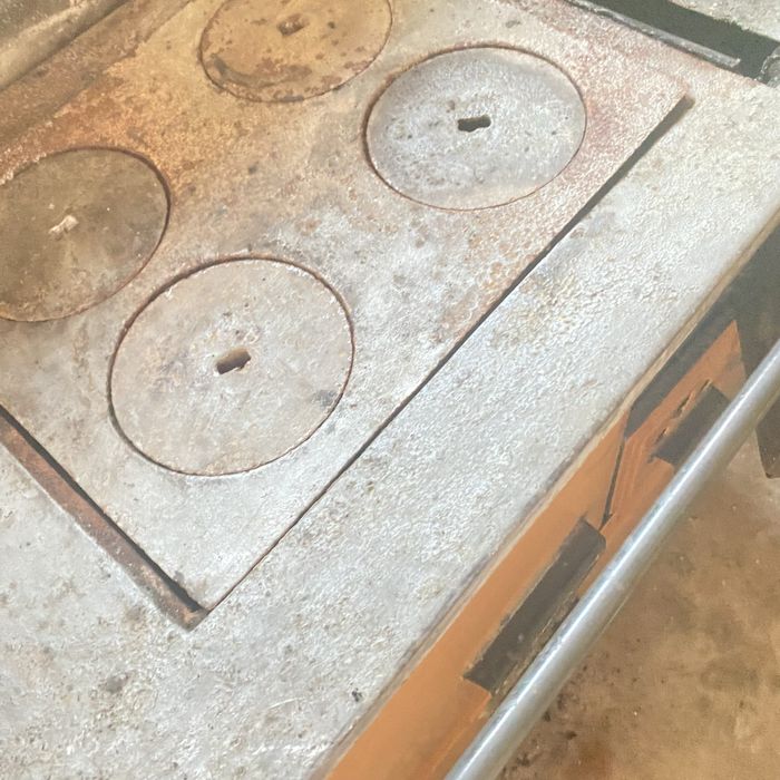 Fogão a lenha vintage degradado para restauro, com torneira agradecido