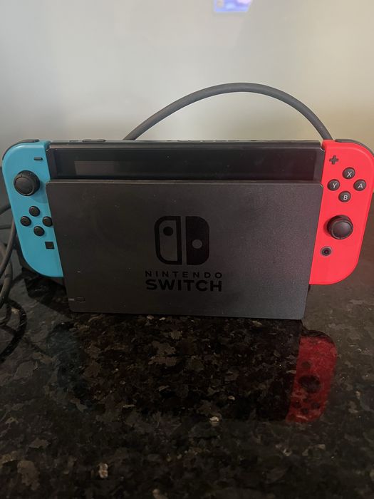 Nintendo Switch com um jogo e os cabos
