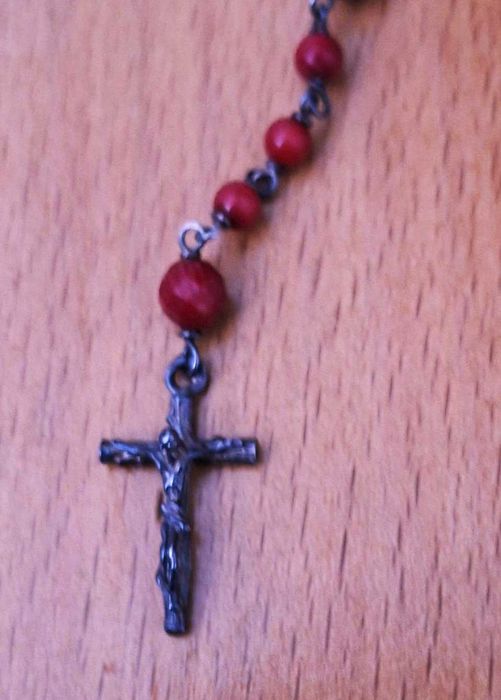 Terço com pedras vermelhas e cruz em prata