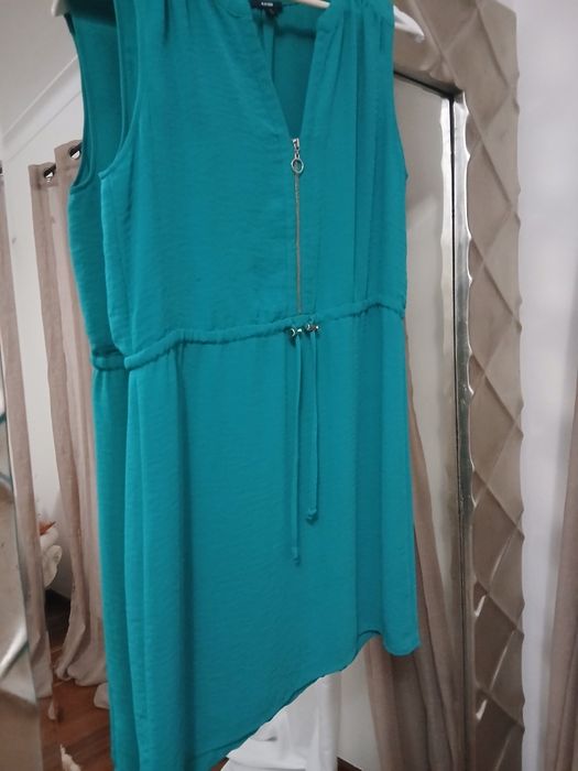 Vestido azul esverdeado, veste pequeno, ligeiramante abaixo do joelho,