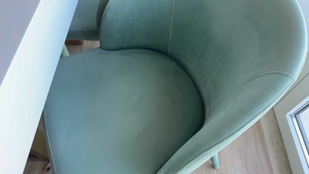 Mesa de jantar branca com acabamento em esmalte cozido e quatro cadeiras em tecido