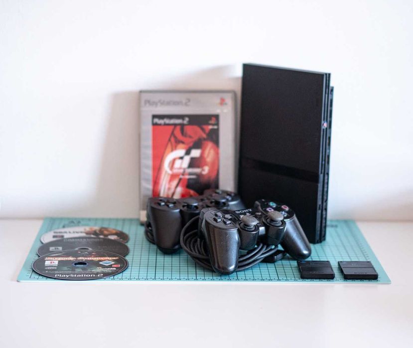Consola PlayStation 2 Slim + 2 Comandos + 2 Memory Cards + 4 Jogos